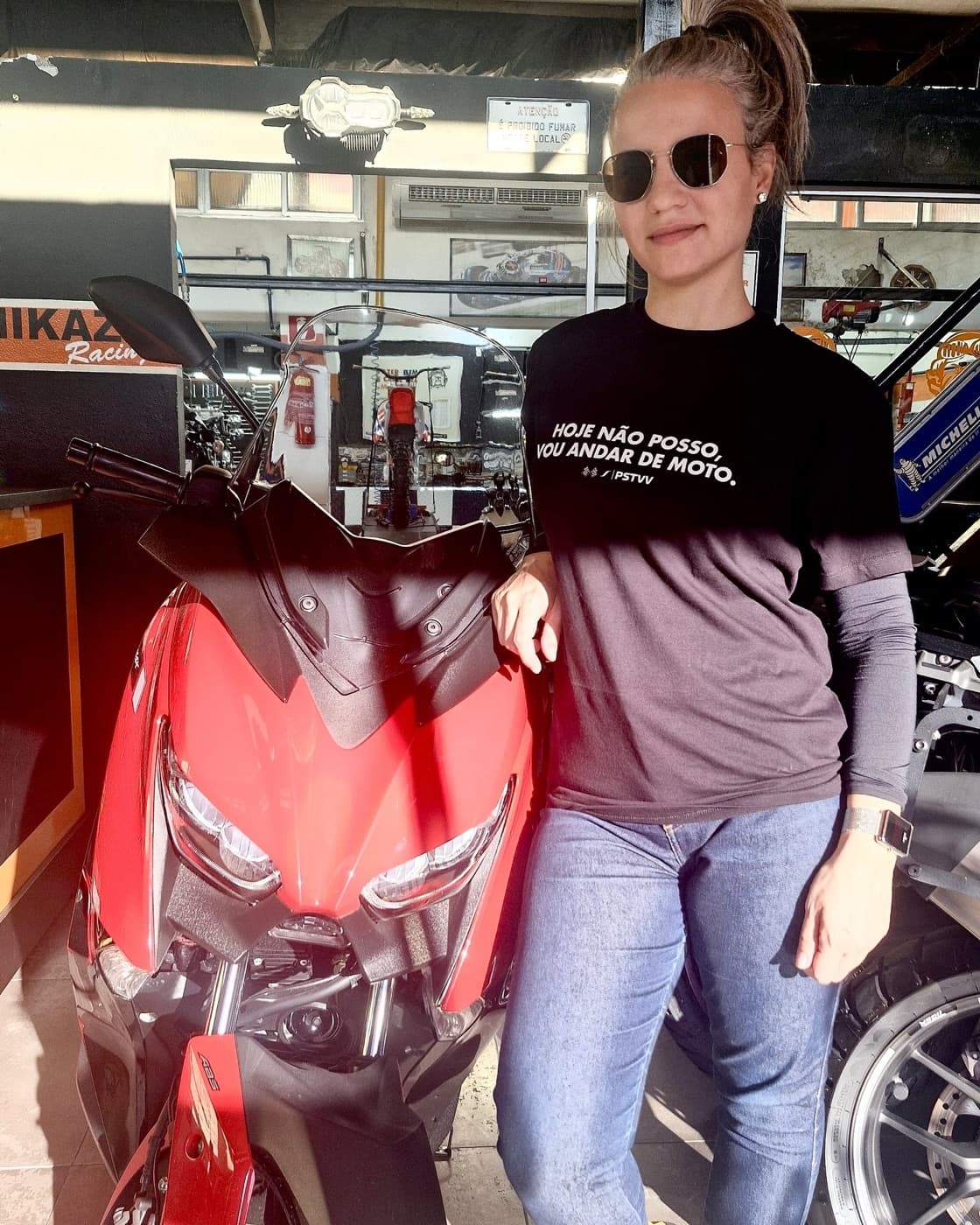 Motociclista usando camiseta Pistaviva ao lado de uma moto vermelha