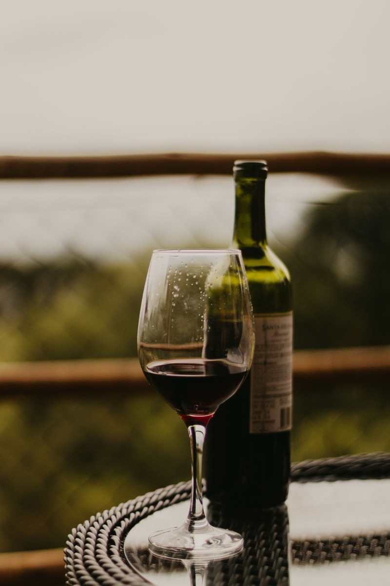 Taça e garrafa de vinho em varanda na Serra da Mantiqueira