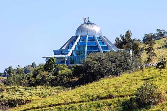 Interior do Santuário Nossa Senhora da Agonia, com a cúpula de vidros azuis sobre os bancos e o altar