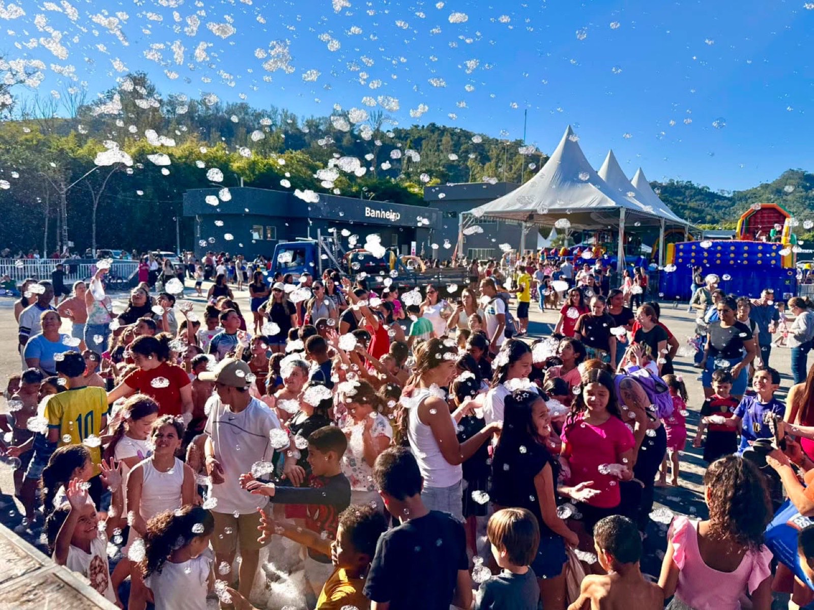 Crianças brincando na festa da espuma no pátio do Parque da Cidade
