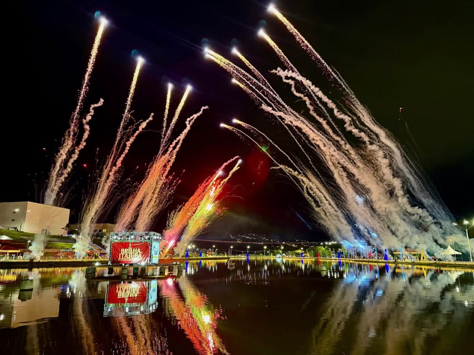 Queima de fogos do Natal Brilha Itajubá refletindo no lago do parque