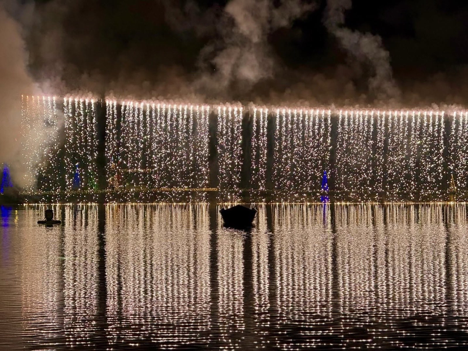 Cascata de fogos iluminando a margem do lago no Natal de Itajubá